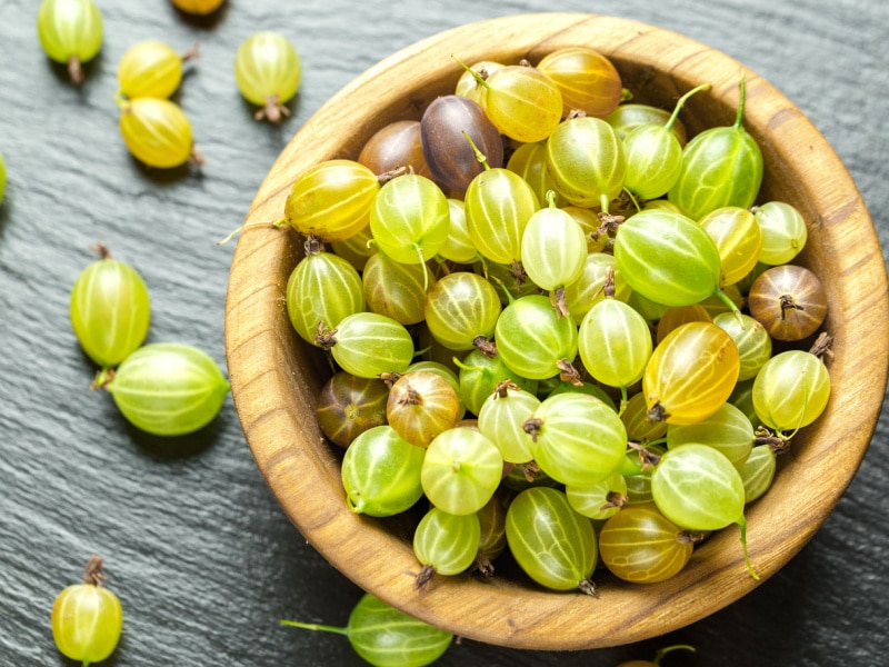 Ripe Gooseberries on a Wooden Bowl
