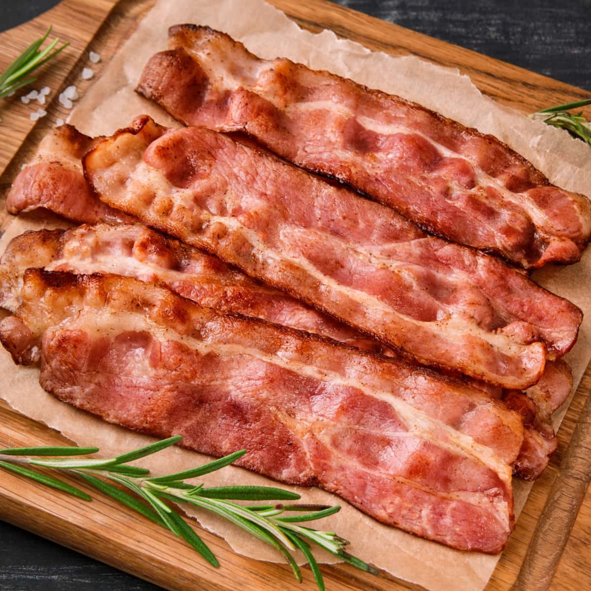 https://insanelygoodrecipes.com/wp-content/uploads/2023/05/Bacon-on-a-Wooden-Cutting-Board.jpg