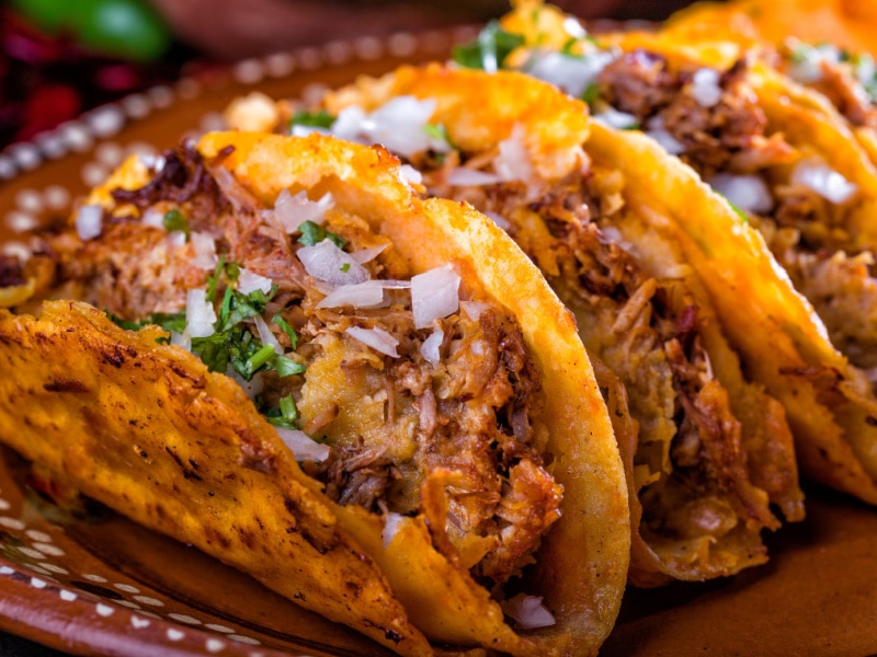Beef Barbacoa Tacos Garnished with Chopped Onions