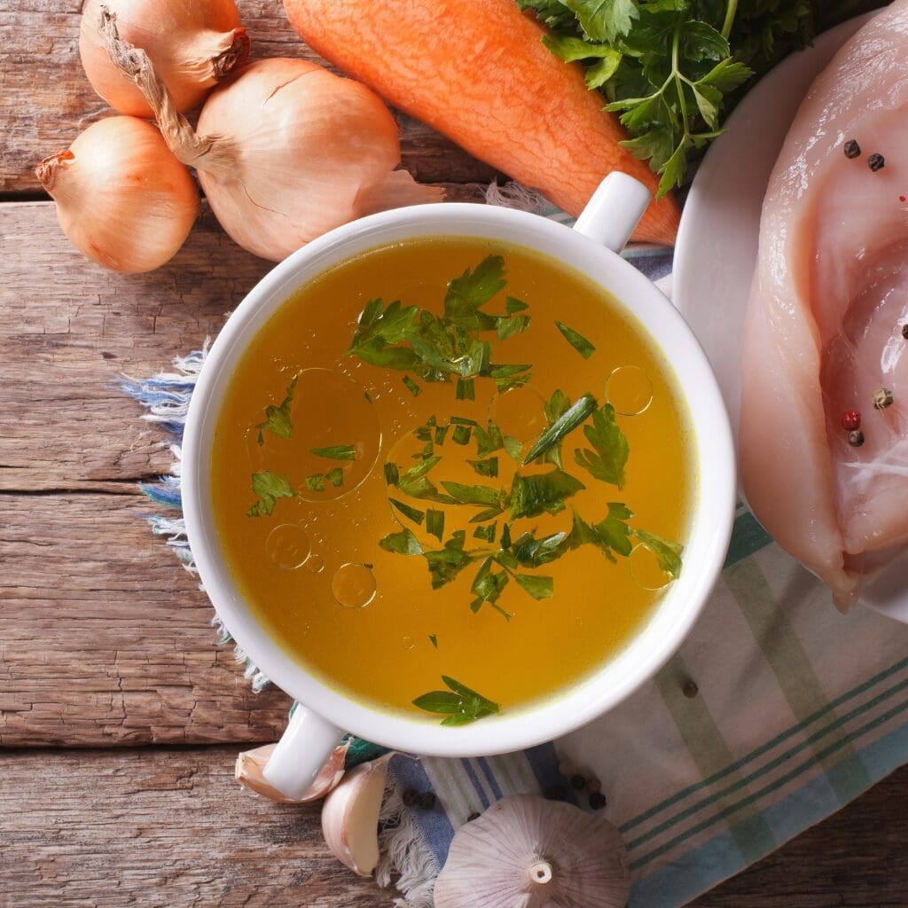 Bowl of Warm Chicken Broth with Herbs