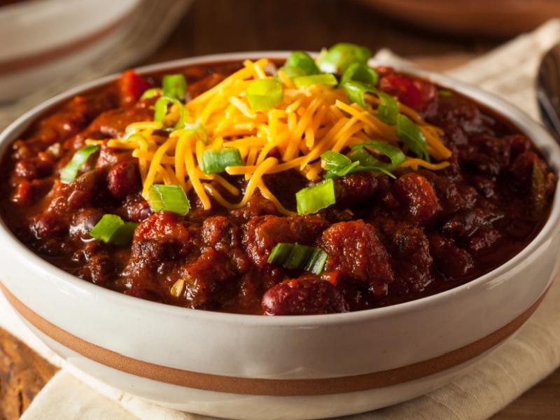 A Bowl of Chili Garnished With Grated Cheese