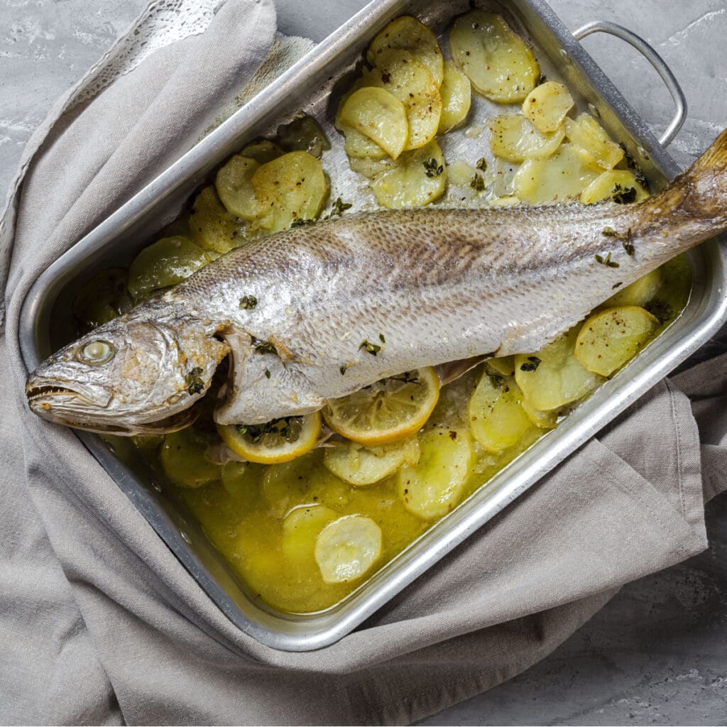 Corvina Fish on a Pan Garnished with Sliced Lemon