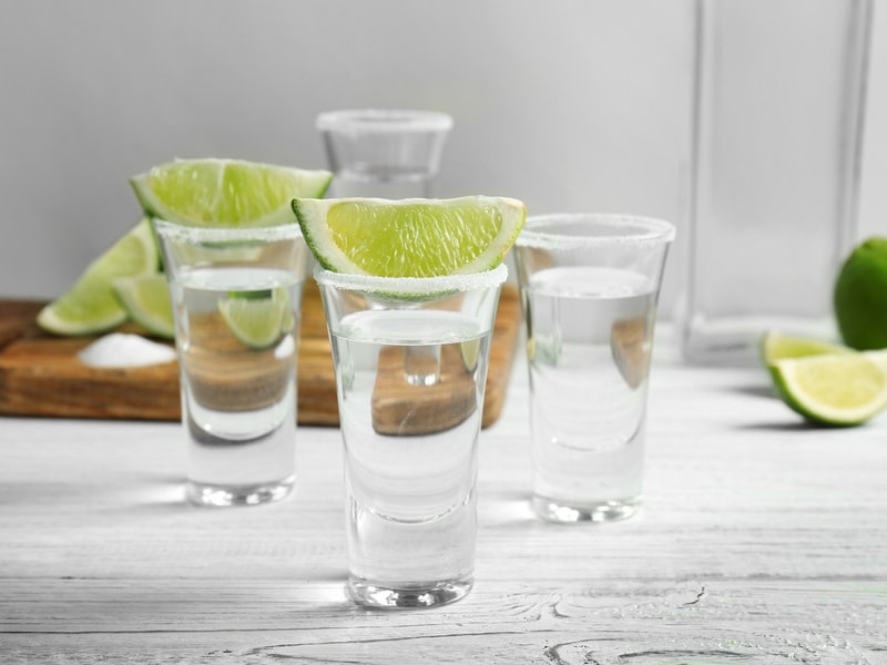 Three Shots of Cristalino Tequila With Lime Slices