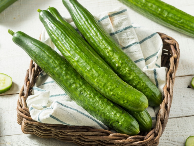Bunch of English Cucumbers in a Woven Basket