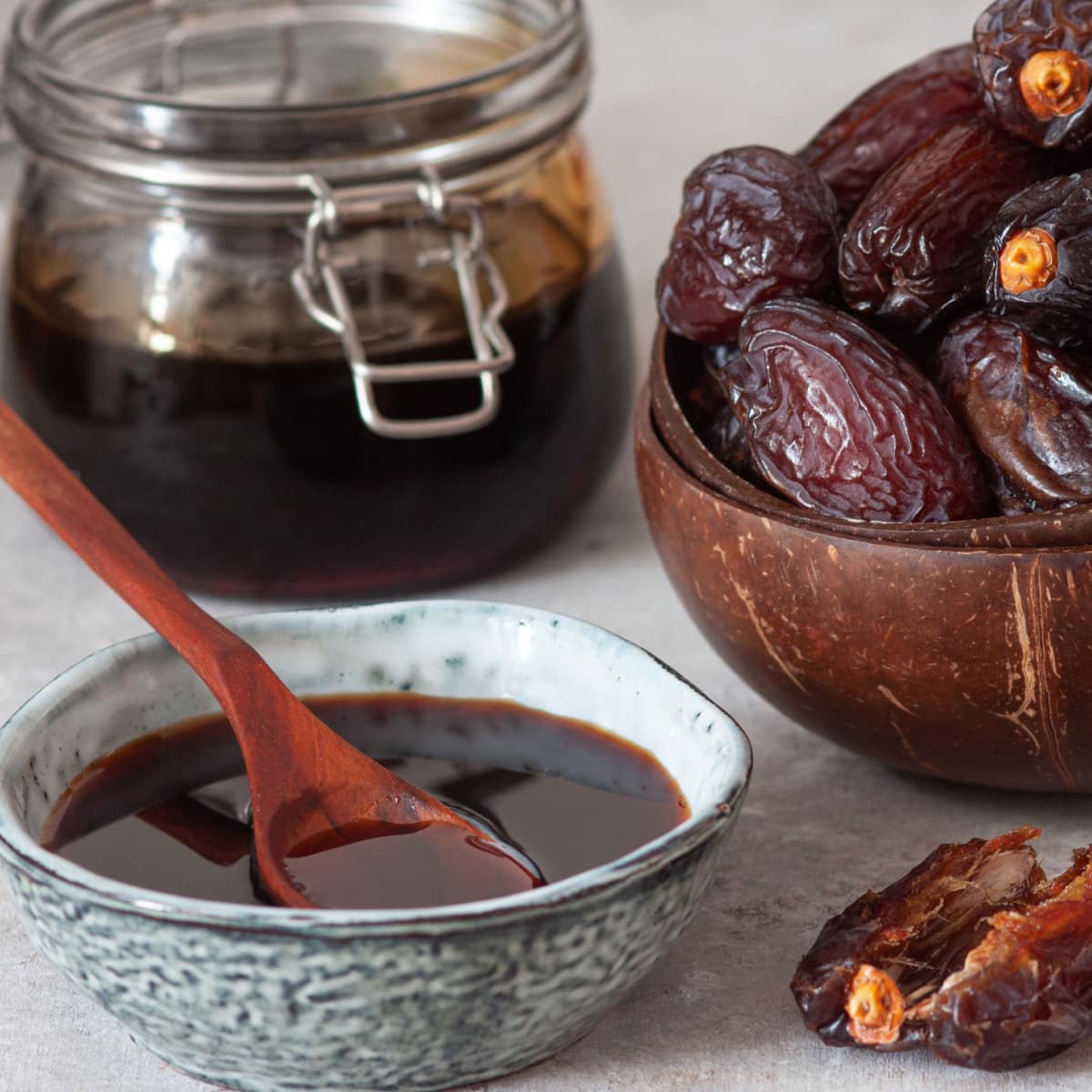Date Syrup in a Bowl with Dates on Background