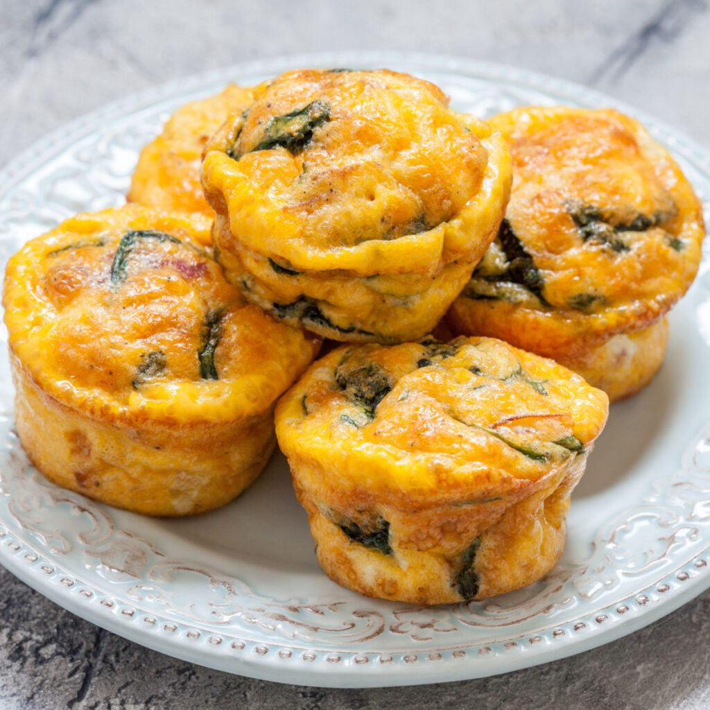 Quiche Muffins Rich with Cheese and Spinach Served on a Ceramic White Plate
