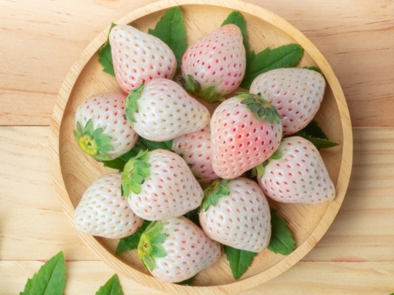 Fresh White Strawberries With Leaves on a Wooden Tray
