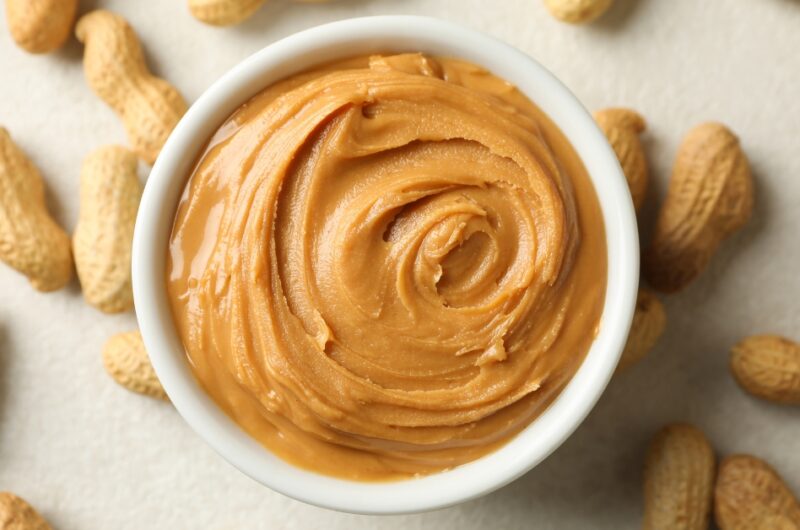 Homemade Peanut Butter in a White Bowl with Peanuts