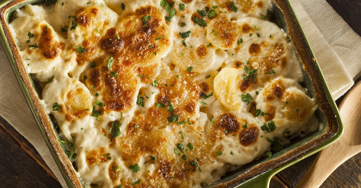 Homemade Scalloped Potatoes with Herbs in a Green Casserole