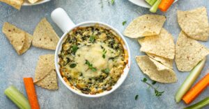 Homemade Spinach Artichoke Dip Served with Chips and Vegetables