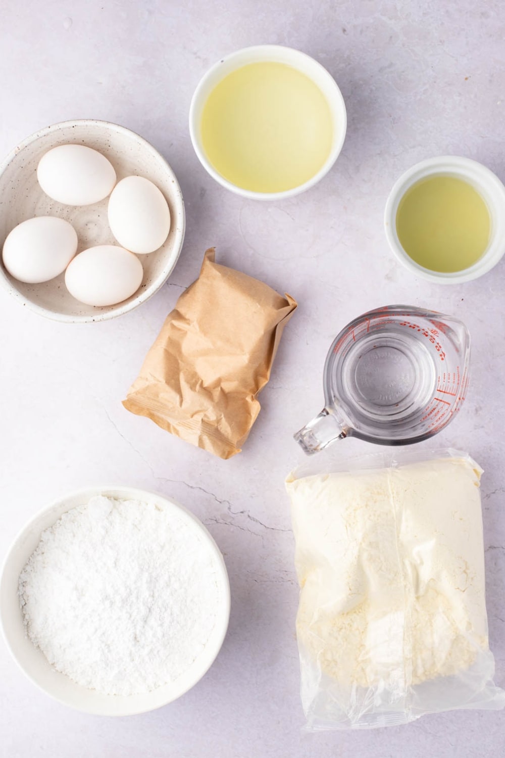 Lemon Poke Cake Ingredients - Boxed Yellow Cake Mix, Lemon Pudding Mix, Water, Vegetable Oil, Eggs, Lemon Juice and Confectioners Sugar