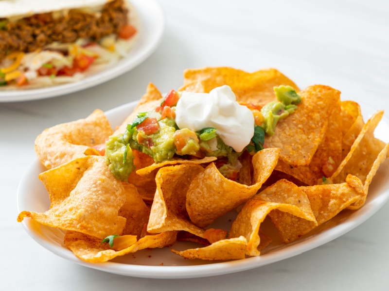 Plate of nachos with guacamole and sour cream