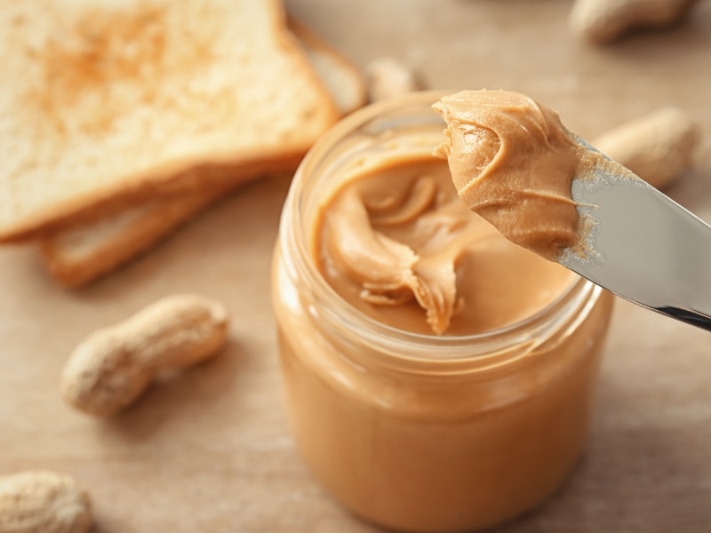 Peanut Butter on Jar Scooped With a Bread Knife
