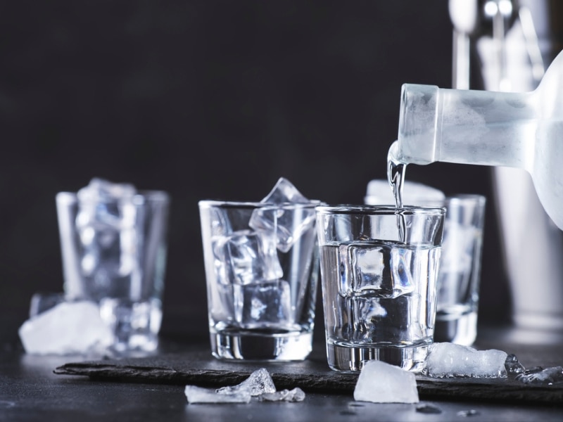 Plain Vodka Poured to Shot Glasses With Ice