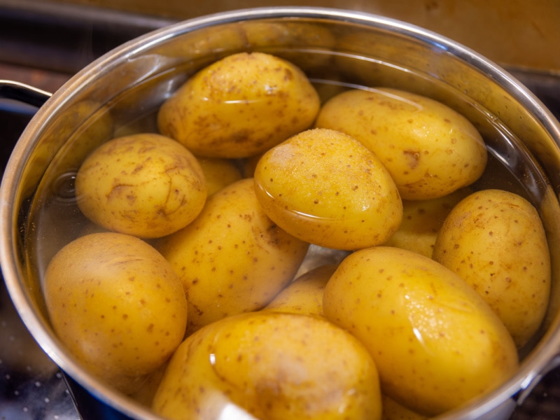 Raw Potatoes on a Stainless Pot Filled With Water Ready For Boiling