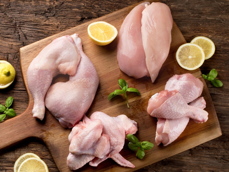 Raw Chicken Cuts on a Wooden Chopping Board