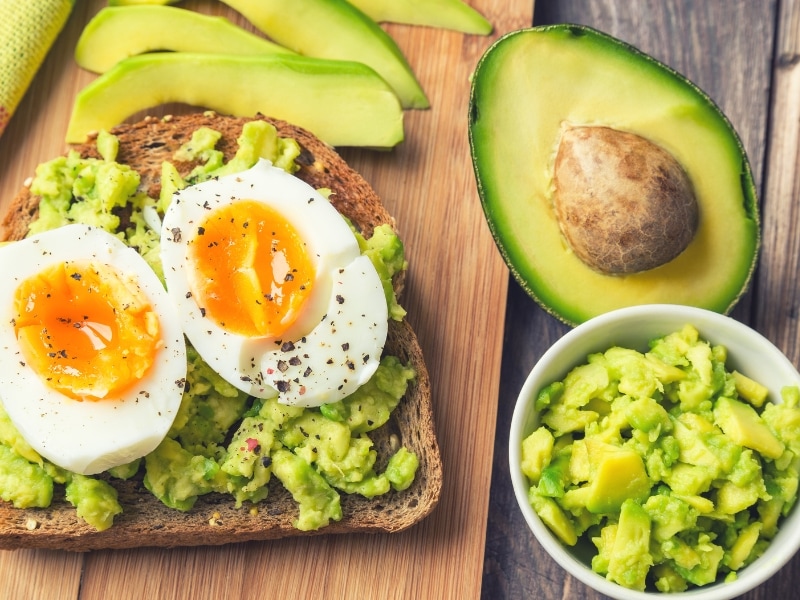 Avocado French Toast Topped With Boiled Eggs, Mashed and Sliced in Half Ripe Avocados