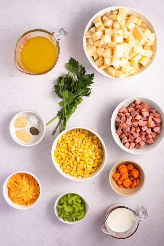 Sausage Potato Soup Ingredients - Smoked Kielbasa, Potatoes, Frozen Corn, Chicken Broth, Celery, Carrots, Sesonings, Milk, Cheddar Cheese and Parsley