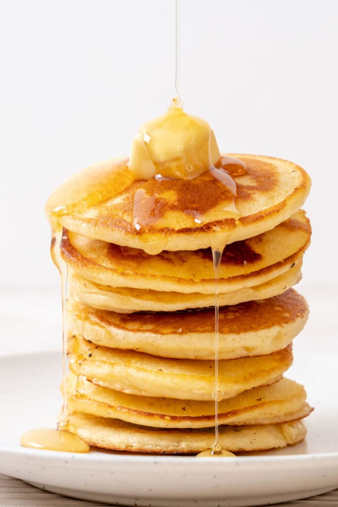 Stack of Homemade Pancake Topped With Butter and Dripping Syrup
