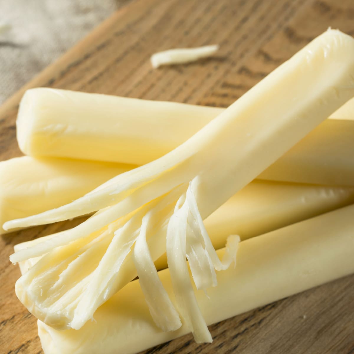 String Cheese on a Wooden Cutting Board