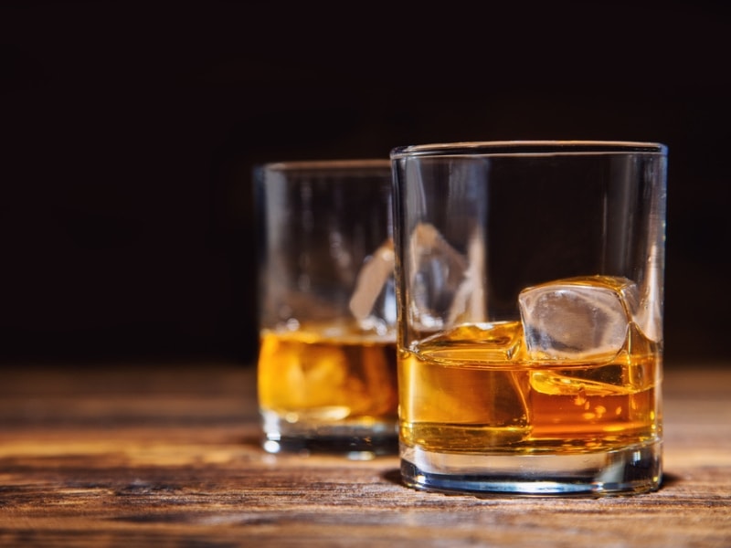 Two Glasses of Whiskey With Ice Cubes Served on Wooden Planks.