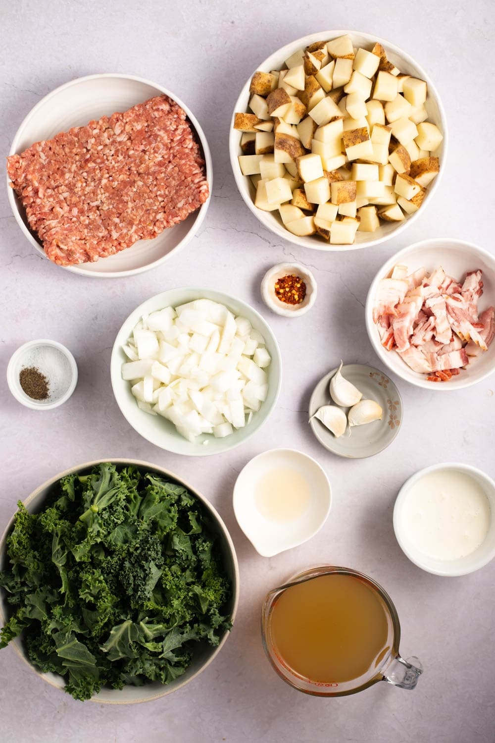 Zuppa Toscanasoppa ingredienser - italiensk korv, bacon, potatis, vitlök, lök, kycklingbuljong, grönkål och kraftig grädde