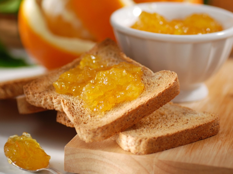 Marmalade Spread On Toasted Bread On Wooden Cutting Board