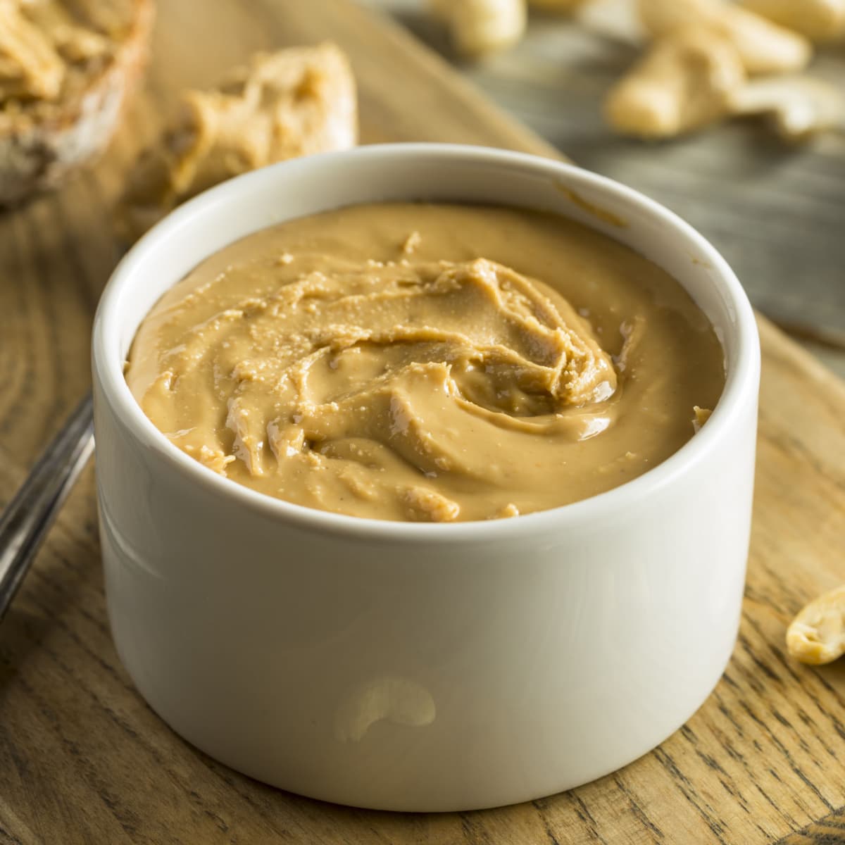 A Bowl of Cashew Butter and Cashews Nuts on a Wooden Table