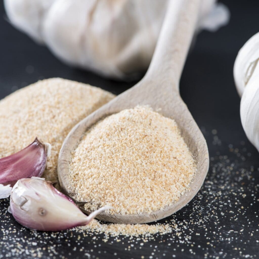 Garlic Cloves and Wooden Spoon With Garlic Powder
