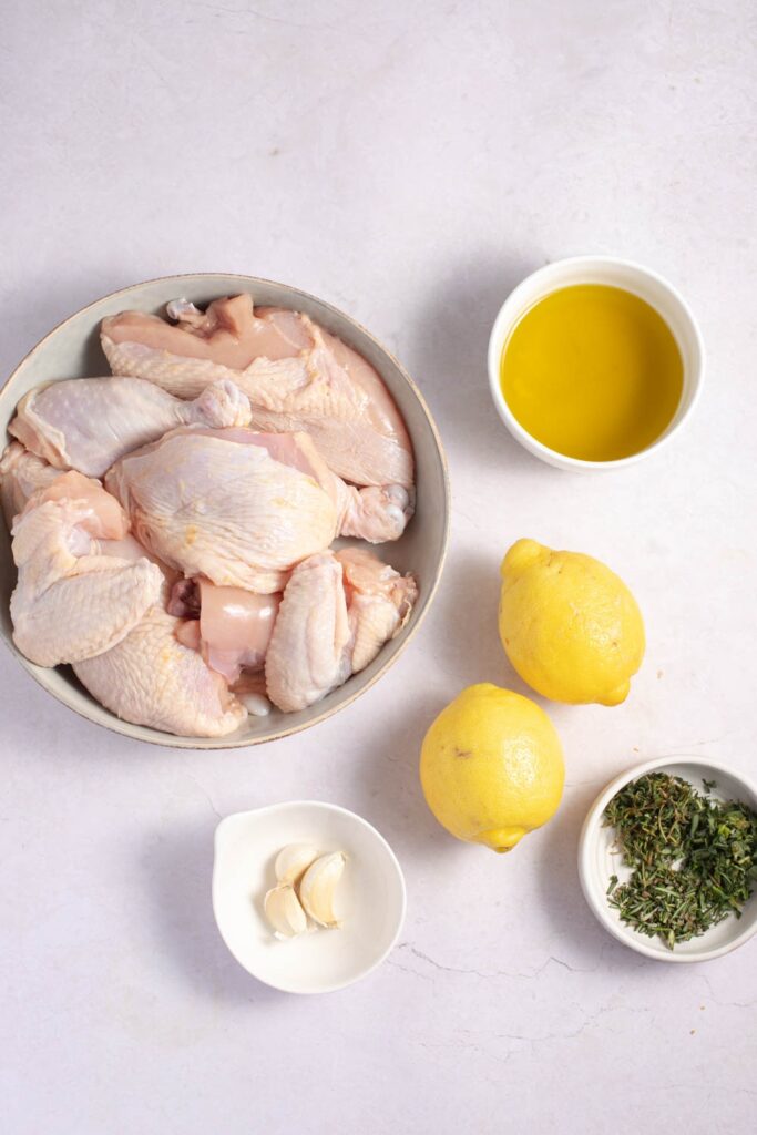 Greek Chicken Ingredients - Olive Oil, Lemons, Garlic Cloves and Fresh Herbs