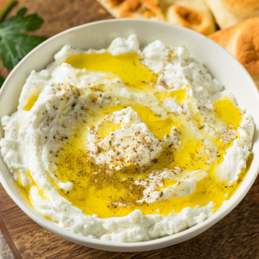 What is Labneh Cheese? (And How to Make It) featuring Homemade Labneh Cheese Dip in a Bowl Topped with Olive Oil and Spices