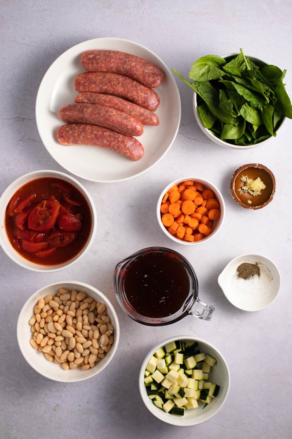 Italian Sausage Soup Ingredients - Sausage, Beans, Beef Stock, Italian Stewed Tomatoes, Veggies, Minced Garlic, Parmesan Cheese and Spices