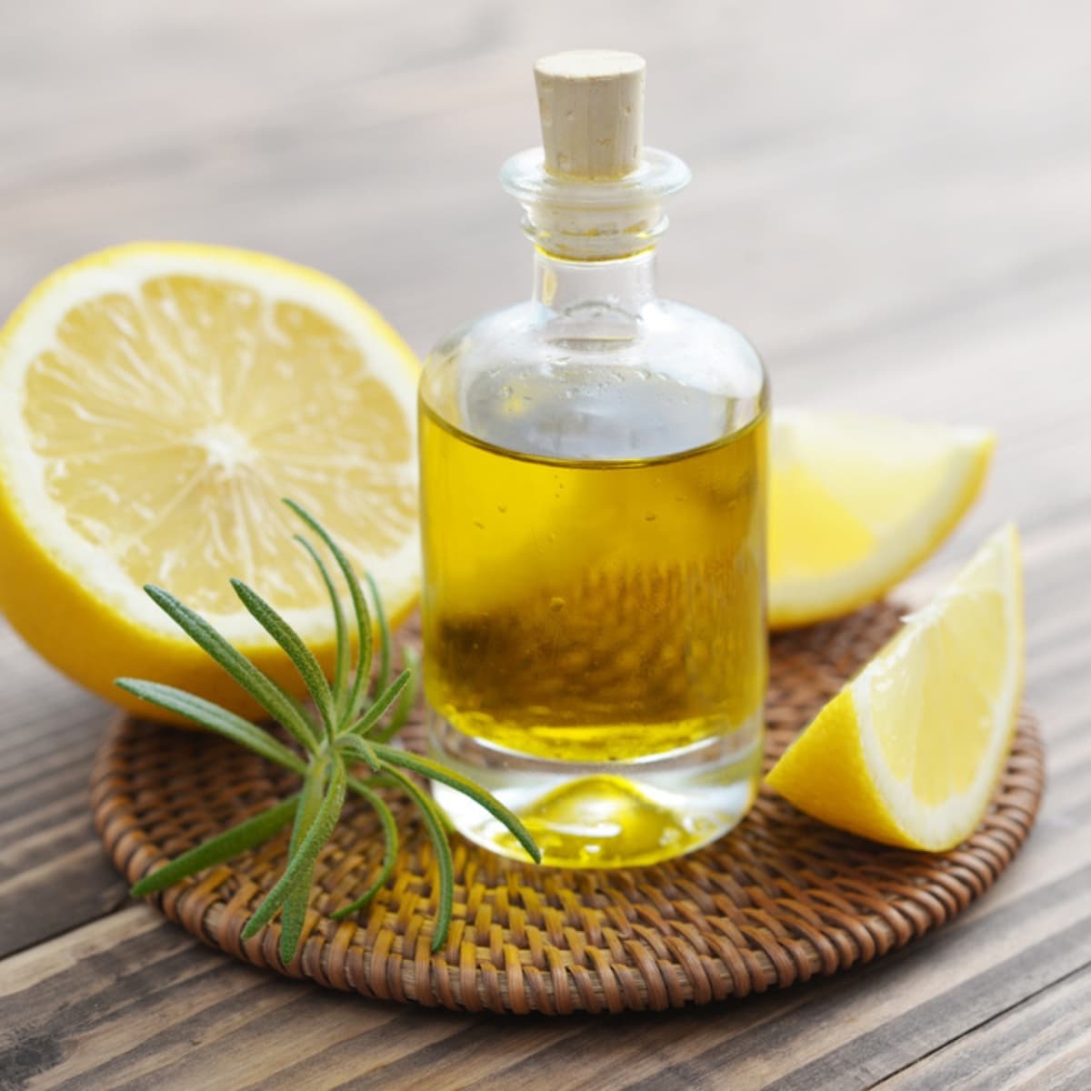 Lemon Oil In A Glass Bottle With Fresh Lemons On Wooden Background