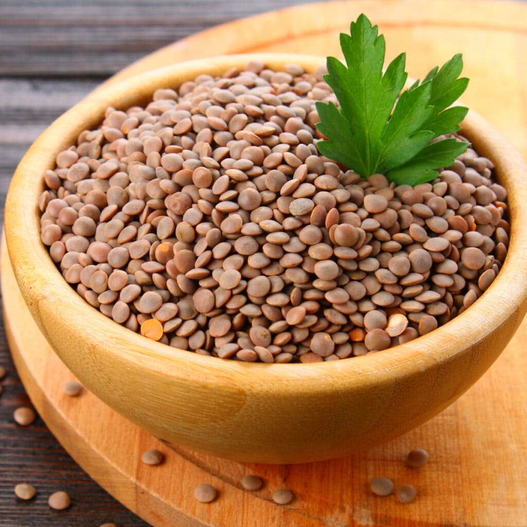 A Heap of Brown Lentils on a Wooden Bowl