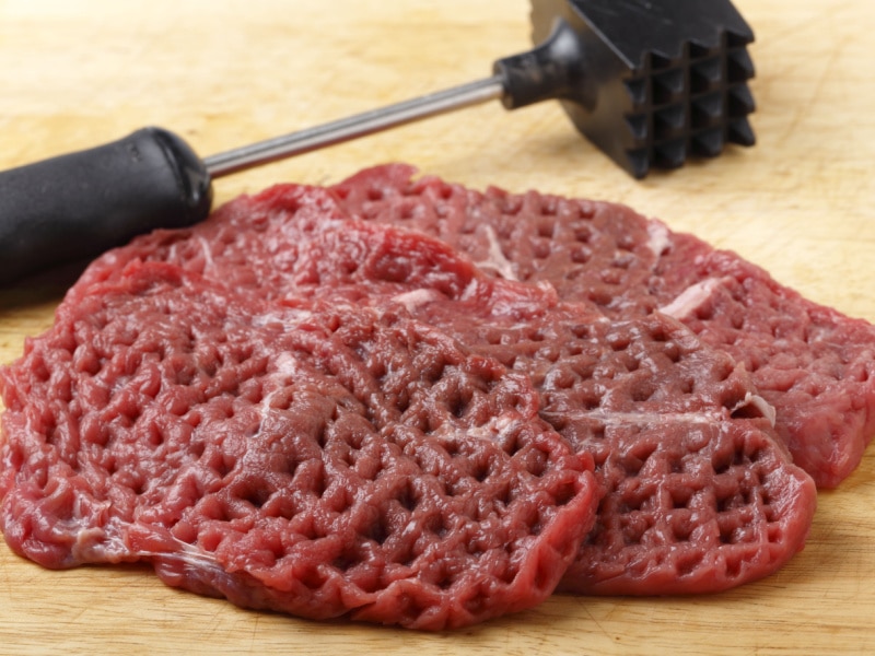Three Slices of Raw Steak Pounded by Meat Mallet