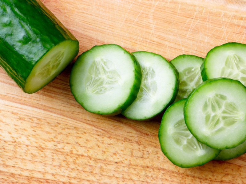 Top View of Freshly Sliced Cucumber on a Wooden Chopping Board