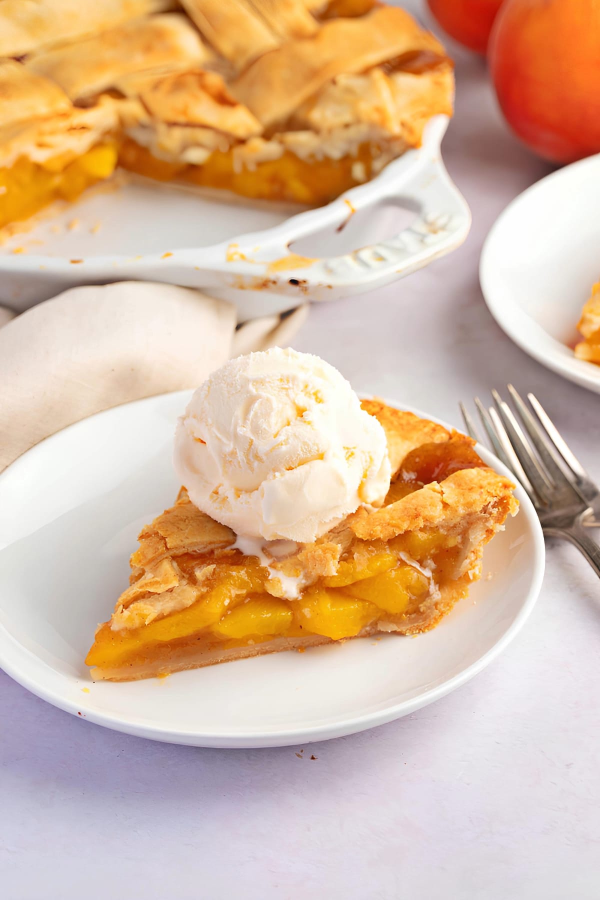 Sliced Homemade Peach Pie with Vanilla Ice Cream on Top