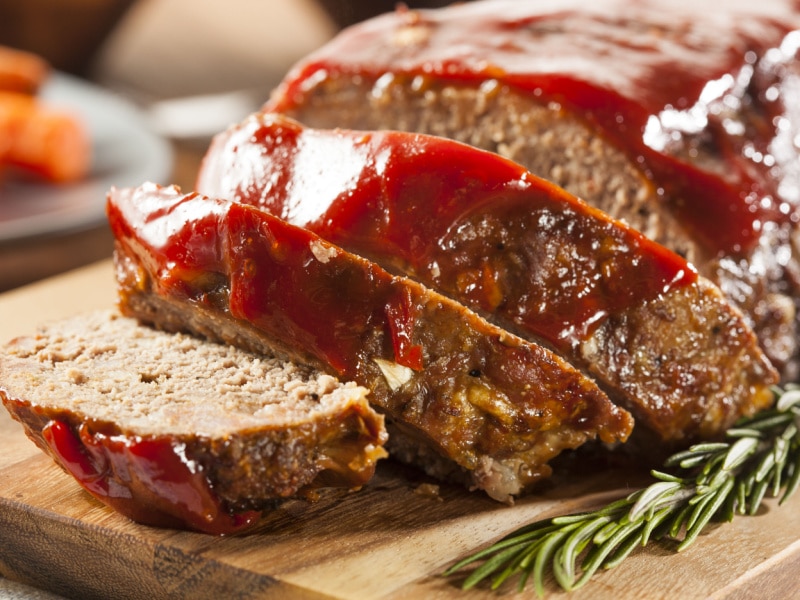 Sliced Meatloaf on a Cutting Board Garnished with Rosemary