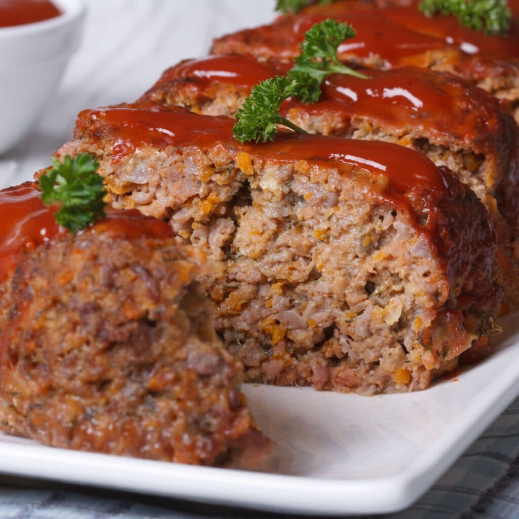 How Long to Bake Meatloaf at 350 (Best Easy Recipe) featuring Sliced Meatloaf with Ketchup and Parsley