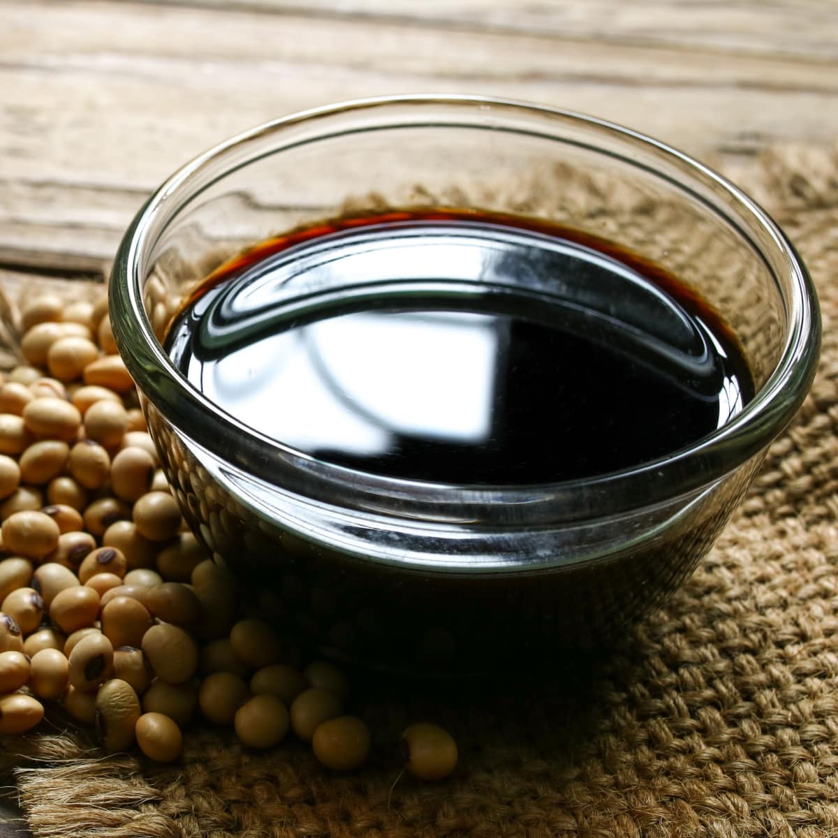 A Bowl of Soy Sauce and Raw Soy Beans on a Rustic Cloth