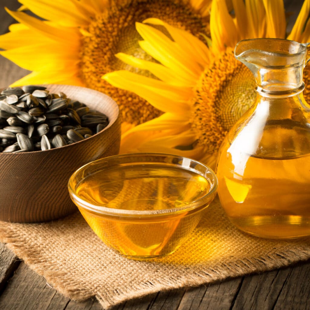 A Bowl of Sunflower Oil and Sunflower Seeds on Wooden Table