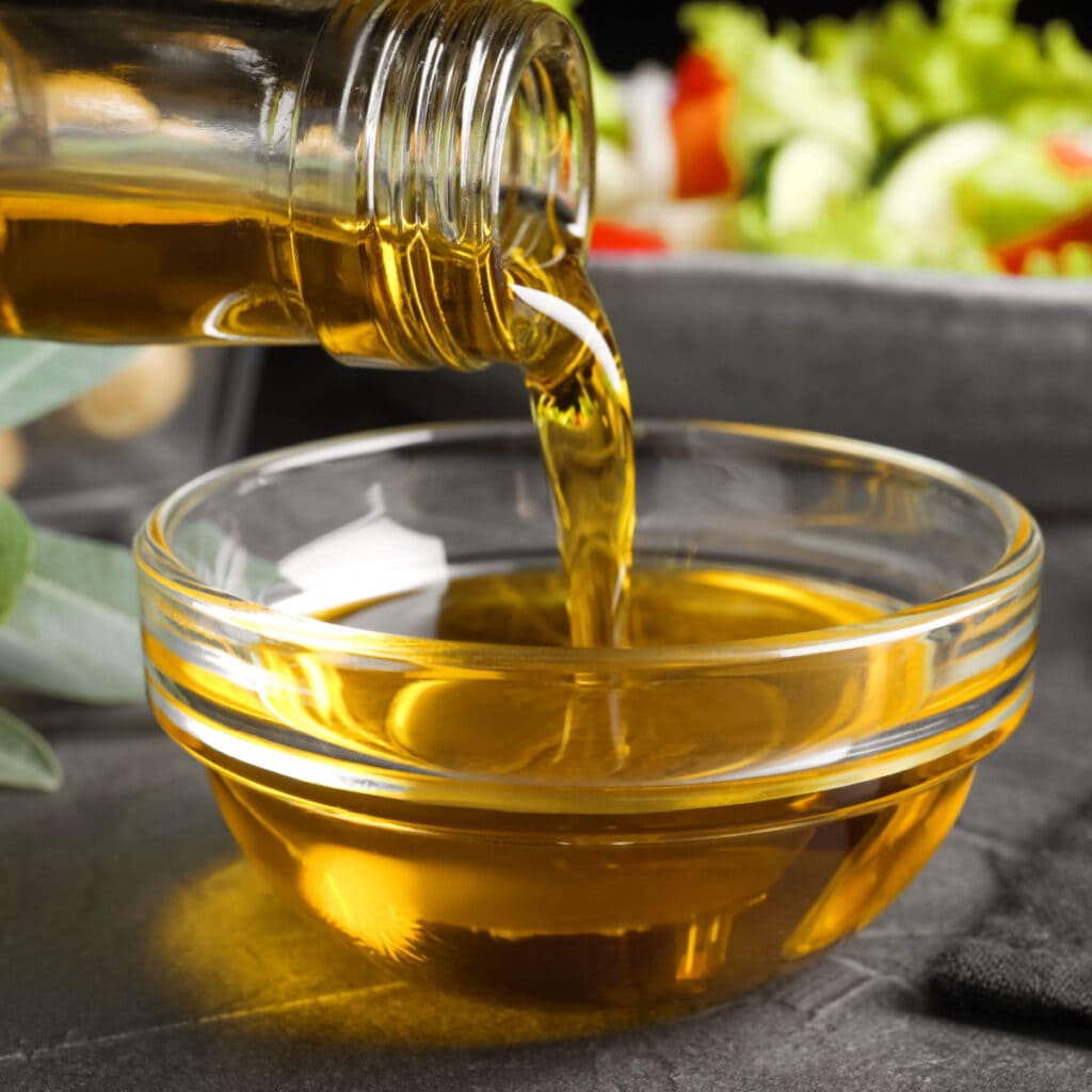 Pouring Vegetable Oil in a Clear Bowl 