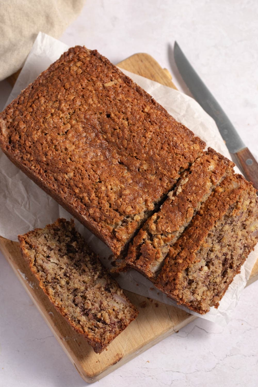 The Best Healthy Oatmeal Banana Bread featuring Partially Sliced Loaf of Warm and Fresh Oatmeal Banana Bread