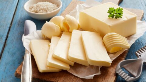 Whole Butter Sliced in a Wooden Cutting Board