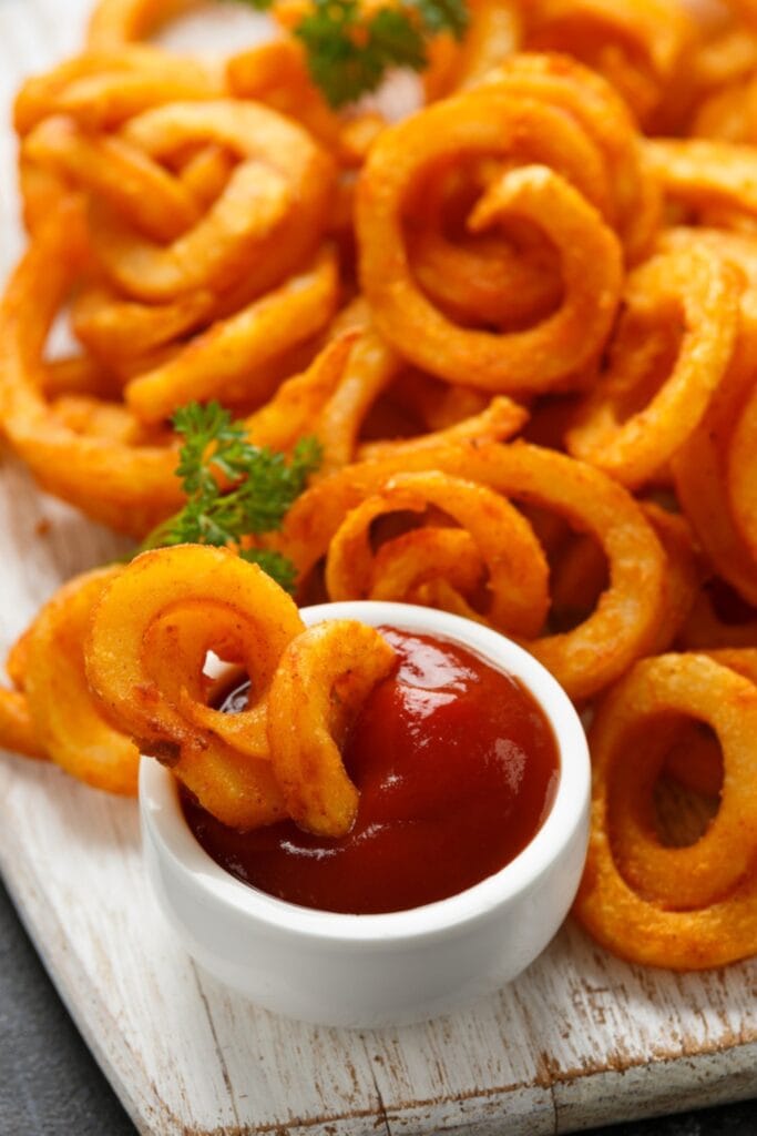 Arby's Curly Fries Dipped in Ketchup