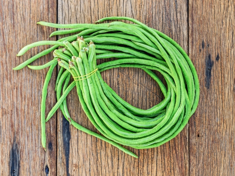 Bundle of Fresh Yard-Long Beans on a Wood Surface