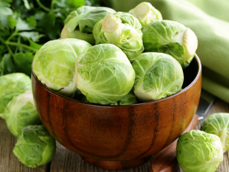 Bunch of Fresh Brussels Sprouts on a Wooden Bowl