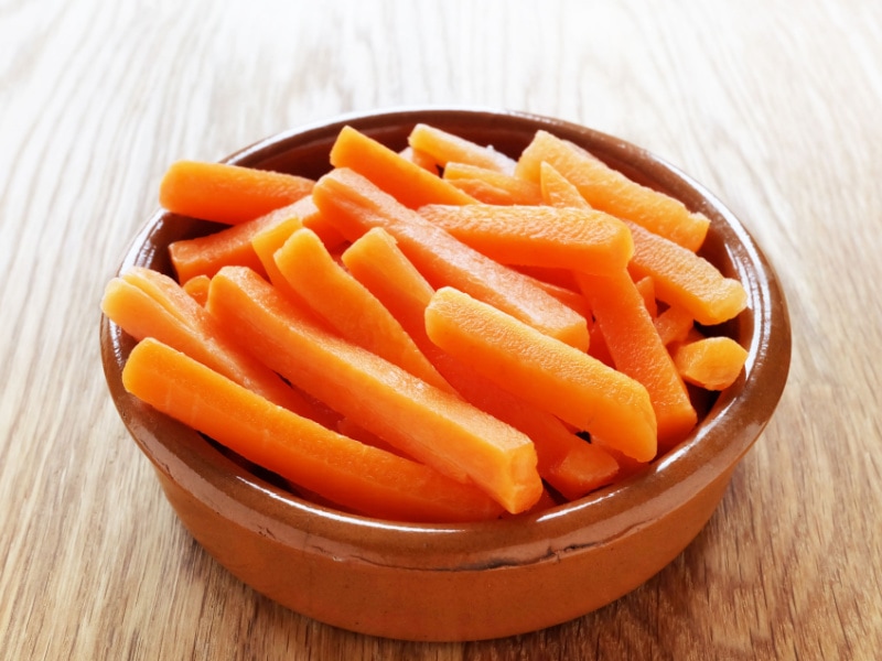 A Bowl of Carrot Sticks on a Wooden Table 