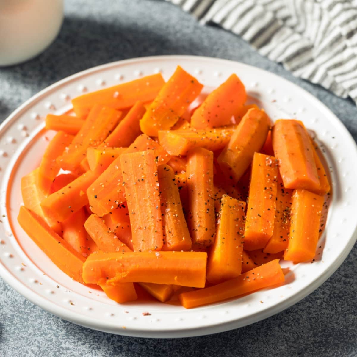 Healthy Homemade Microwave Steamed Carrots on a Plate, Seasoned with Salt and Pepper