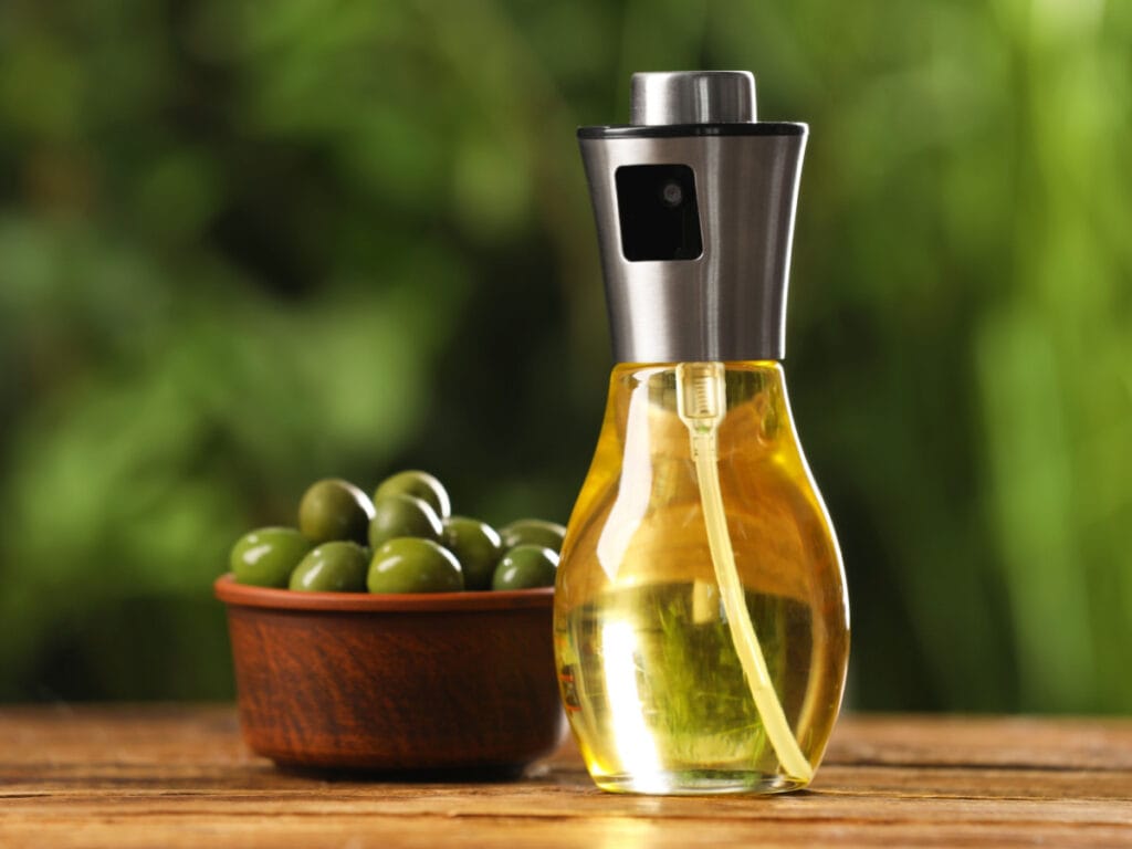 Olive Oil on a Spray Bottle and a Bowl of Fresh Olives